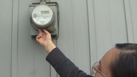 Josie Gagne points to the spot where she found the load limiter re-set button on her meter. She says any time she used too much electricity at once she was forced to reset her meter outside. Josie Gagne limiter