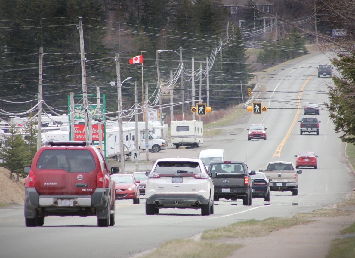 Several cars drive down a Nova Scotia highway on a cloudy day.
