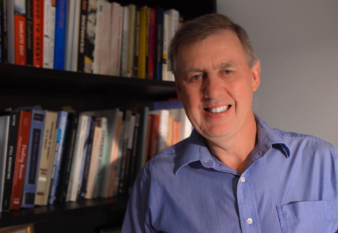 Steve Pomeroy standing in front of a bookshelf.