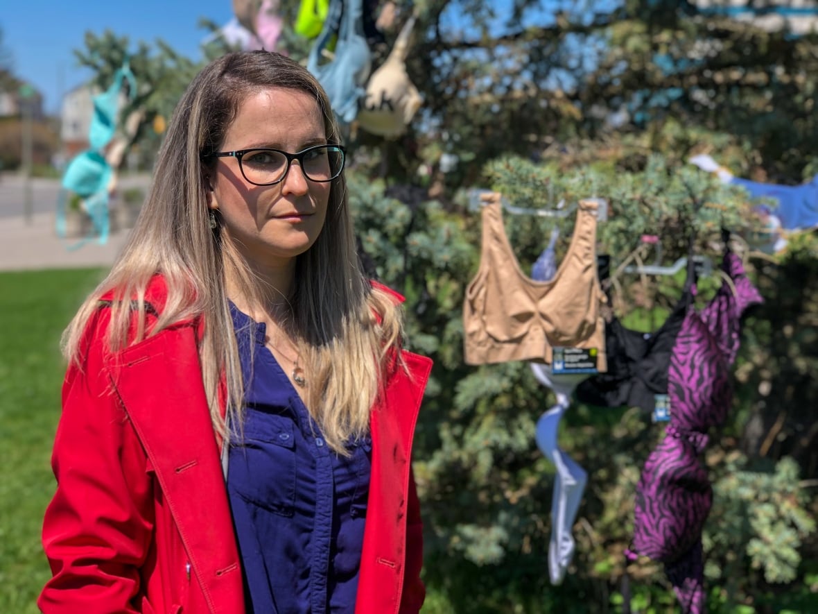 Portrait of a woman with bras in the background.