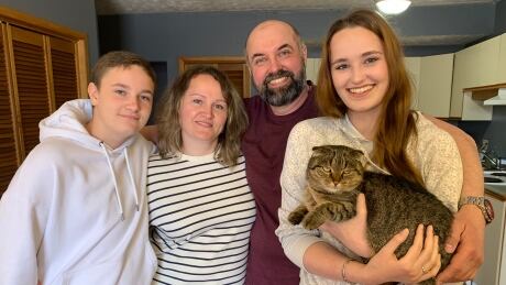 Anatolii Merdukh, the family's father (centre), is pictured at home in P.E.I. with his wife Oksana, 16-year-old daughter Diana, 13-year-old son Arsenii, and their cat named Mikki. ukraine-family-beef-plant 1