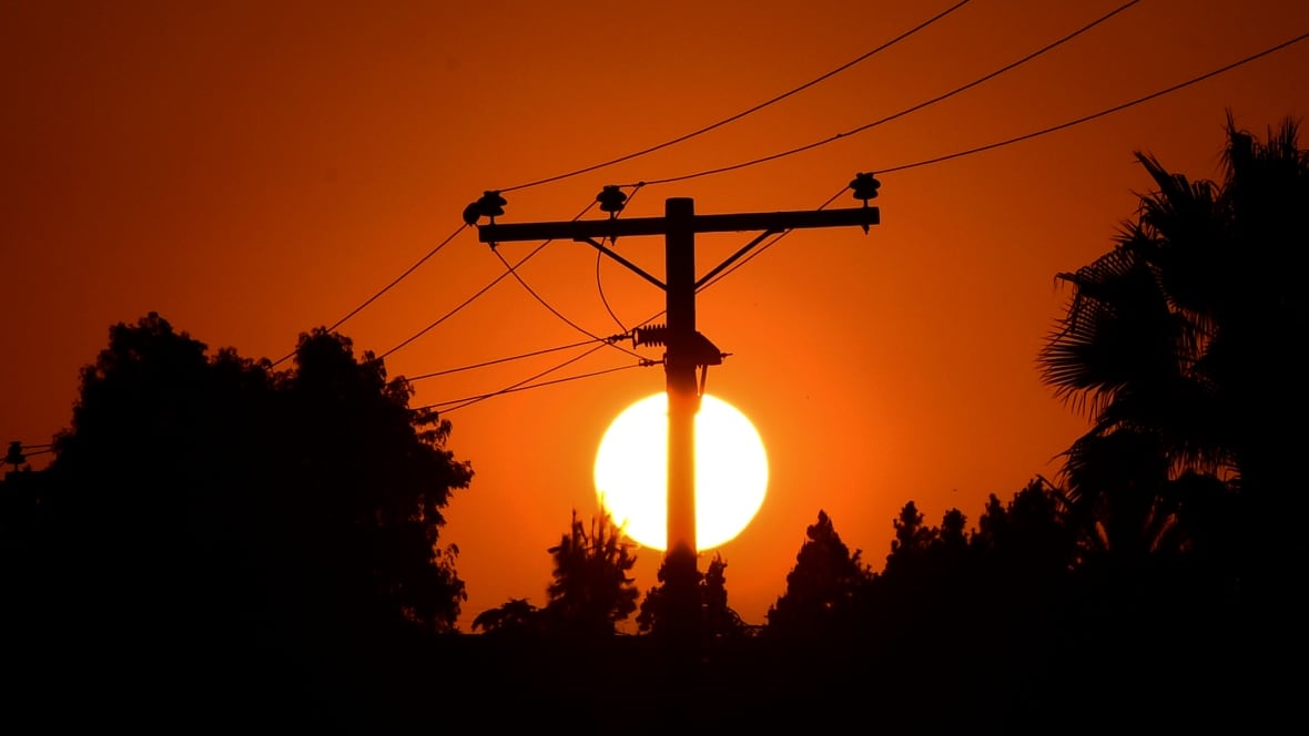 Sunset behind a hydro pole