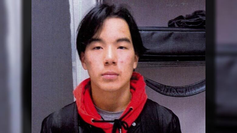 A teenage boy is standing facing the camera.