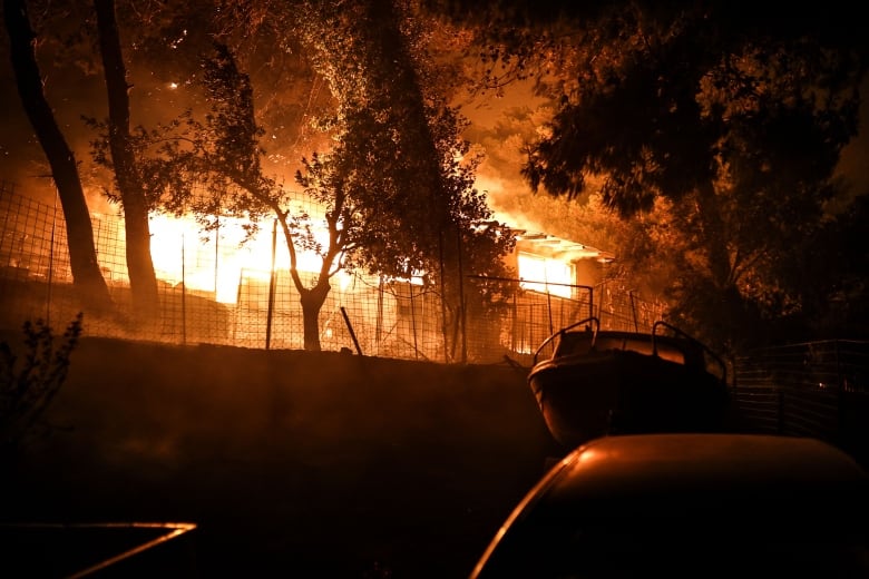 Um incêndio em casa é mostrado em uma cena noturna.