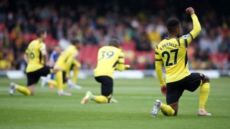 Watford FC players take a knee before the start of an English Premier League soccer match with visiting Leicester City in May. WatfordFC-knee-15052022