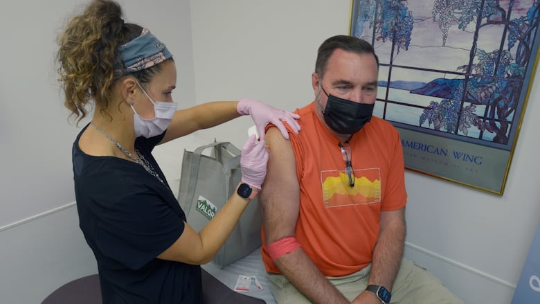 A man receives an injection from a nurse.