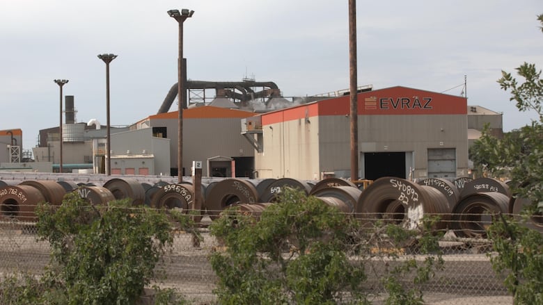 Large circular objects sit in front of a building that says Evraz.