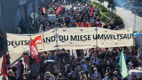 A giant banner rests on one of dozens of tents set up during the System Change Camp protest zone in a park near Hamburg’s city center in August 2022. LNG protests Hamburg germany