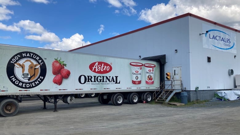 A large warehouse with a trailer attached.