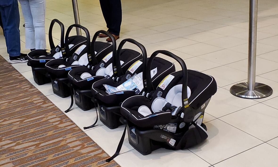 Five child car seats lined side by side on the floor.