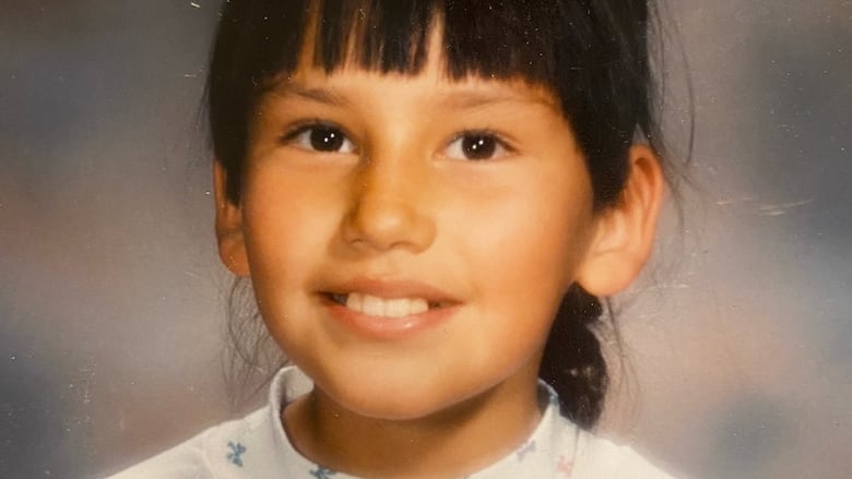 A smiling girl with bangs.