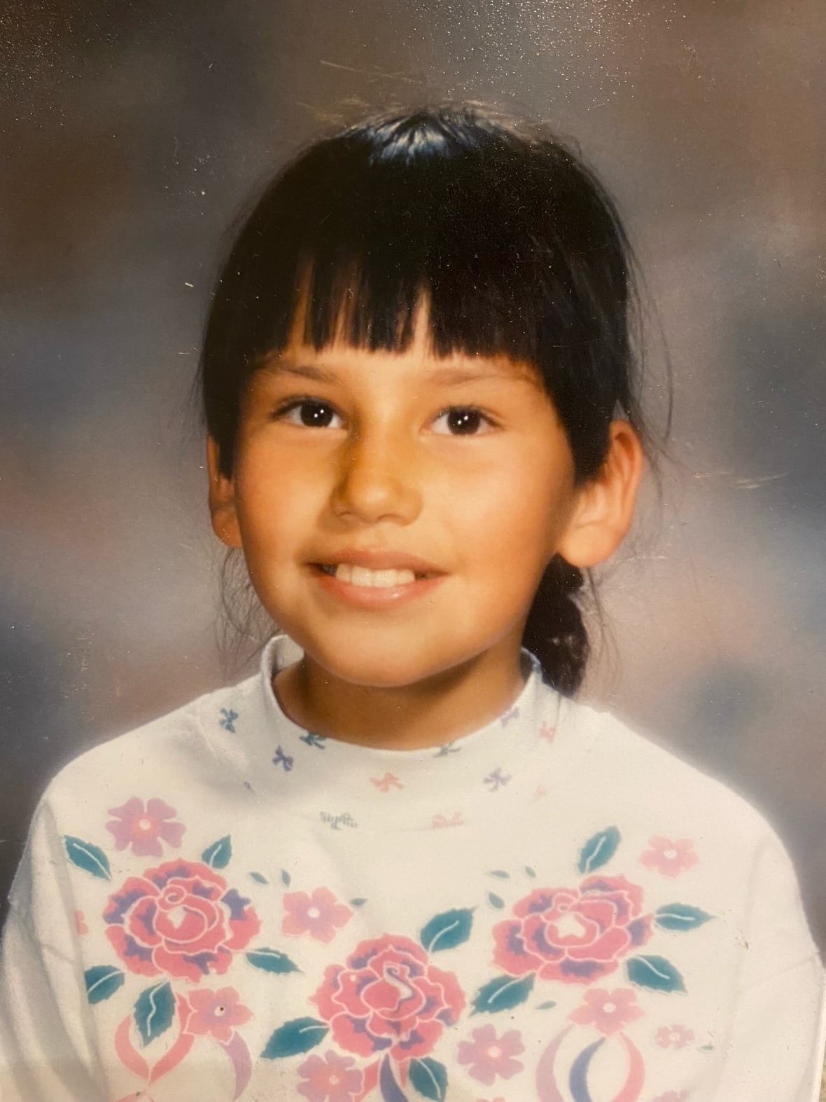 A smiling girl with bangs. 