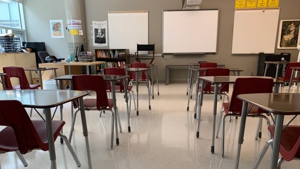 Parents are being encouraged to monitor their children for illnesses and keep them home if they're unwell, but students won't be sent home for having the sniffles, school officials say. Desks and red plastic chairs in a classroom.