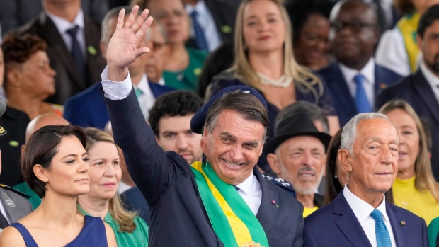 In Brazil, fears of Jan. 6-style post-election violence increase as president casts doubt on voting system; Brazil's President Jair Bolsonaro waves during a military parade to celebrate the bicentennial of the country's independence from Portugal in BrasÃ­lia, Brazil, Wednesday, Sept. 7, 2022. At left is his wife Michelle Bolsonaro and at right Portugal's President Marcelo Rebelo de Sousa. (AP Photo/Eraldo Peres)