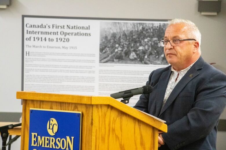 A man stands at a podium speaking.