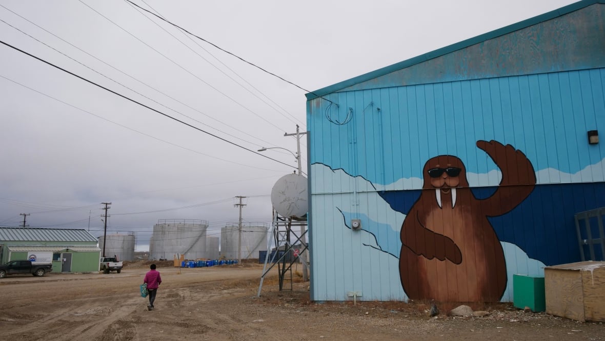 A woman walks through a community on an overcast day.