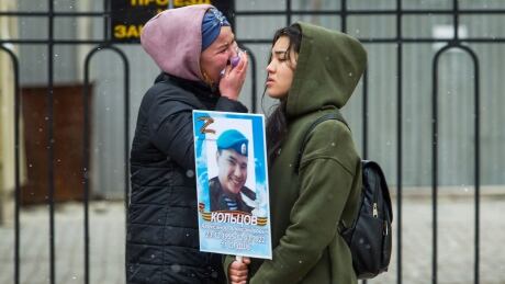 Women cry as they hold a portrait of Russian Army serviceman Alexander Koltsov, who was killed during fighting in Ukraine, during the Immortal Regiment march in Ulan-Ude, the regional capital of Buryatia, a region near the Russia-Mongolia border, Russia, Monday, May 9, 2022, marking the 77th anniversary of the end of World War II. (AP Photo) Russia Victory Day