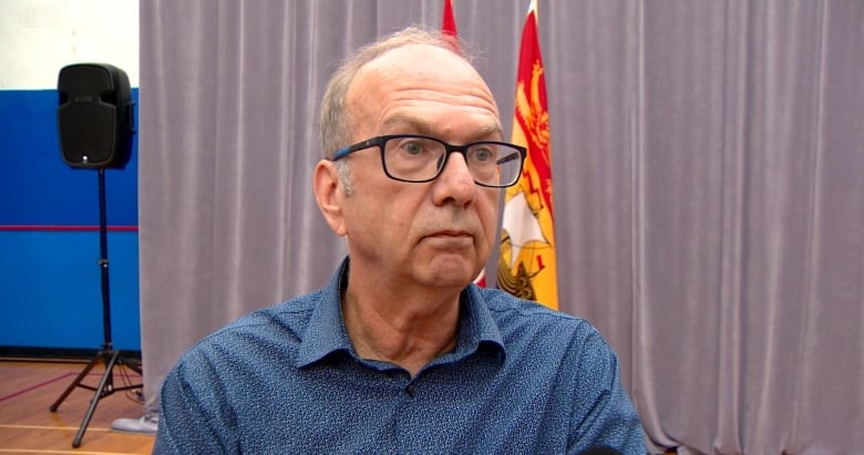 Man in blue shirt and glasses.