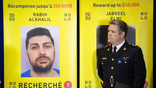 RCMP deputy commissioner Dwayne McDonald stands next to a wanted sign for fugitive Rabih Alkhalil. 