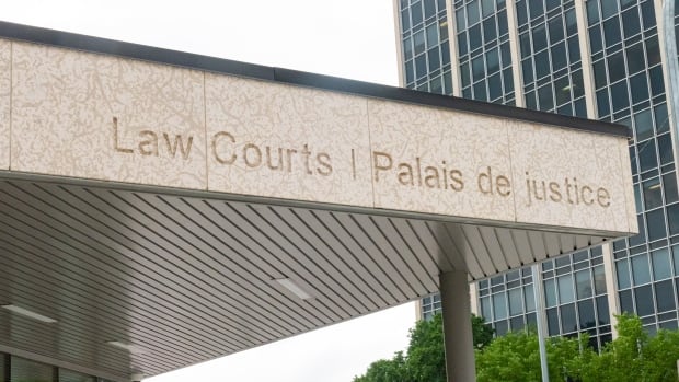 The limestone facade of a building is inscribed with the words "Law Courts" and "palais de justice."