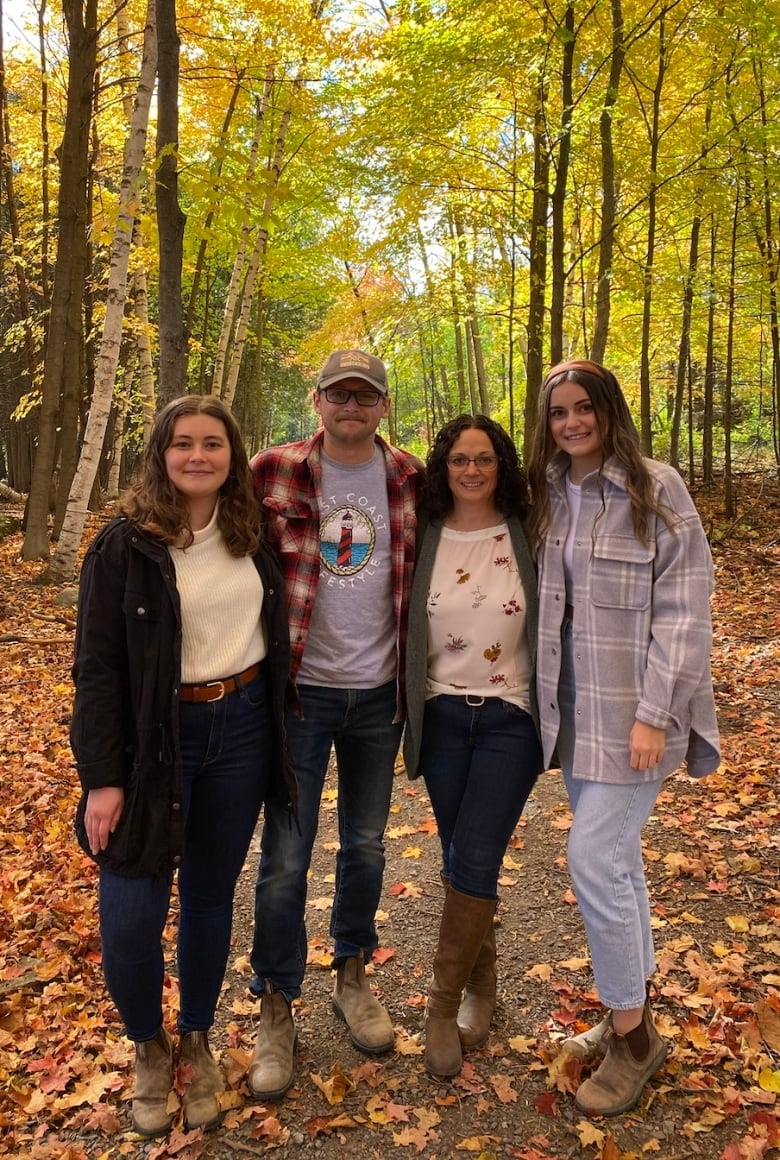 Family photo in front of autumn leaves.