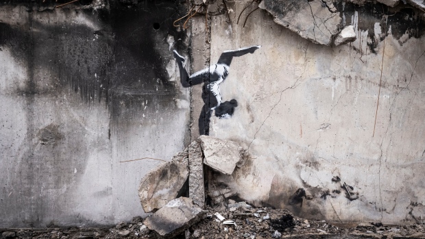 Banksy unveils mural in war-scarred Ukrainian town; BORODYANKA, UKRAINE - NOVEMBER 11 Graffiti of a woman in a leotard doing a handstand is seen on the wall of a destroyed building in Borodyanka on November 11, 2022 in Kyiv Region, Ukraine. Similar art work nearby sparked online speculation over whether the graffiti artist Banksy has been working in Ukraine. Banksy later confirmed on their Instagram account that it was their work. Borodyanka was hit particularly hard by Russian airstrikes in the first few weeks of the conflict. Electricity and heating outages across Ukraine caused by missile and drone strikes to energy infrastructure have added urgency to preparations for winter