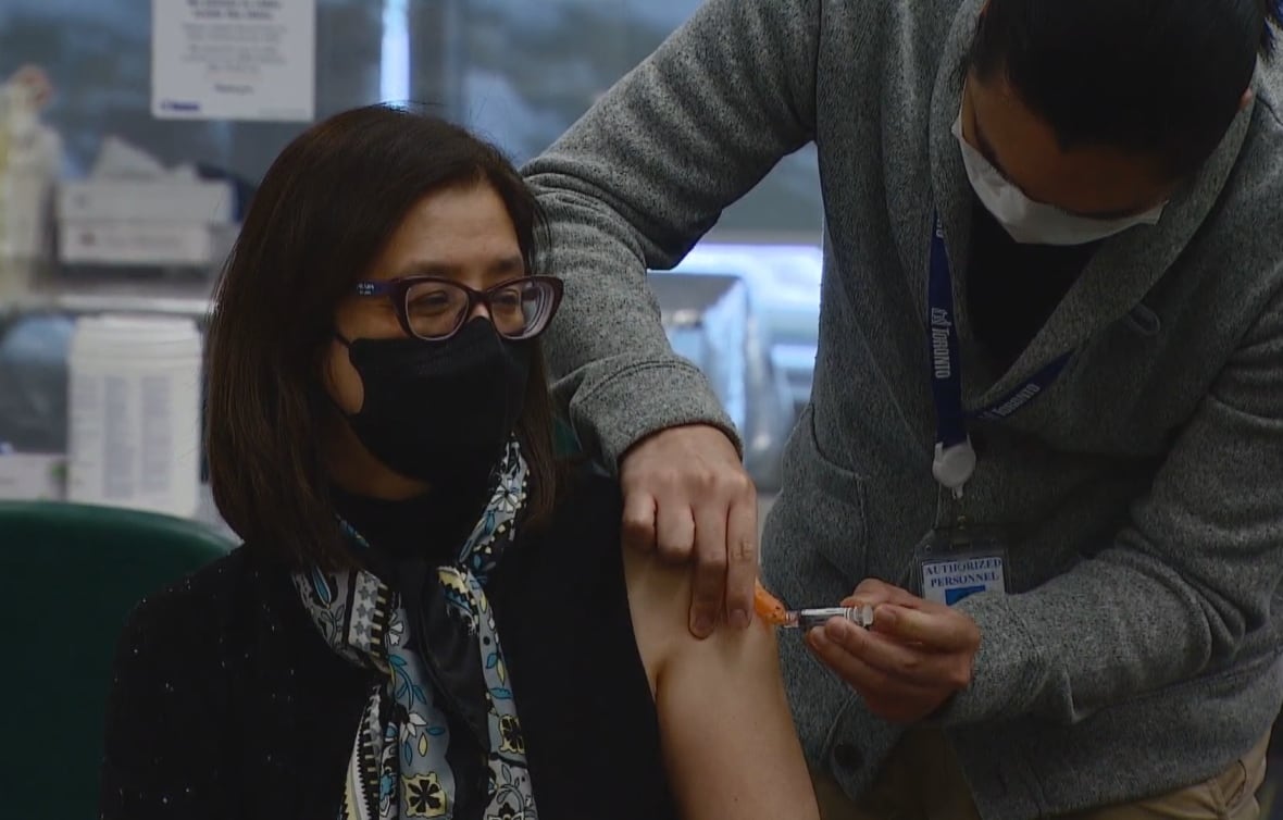 Dr. Eileen de Villa is getting a flu shot in her arm.