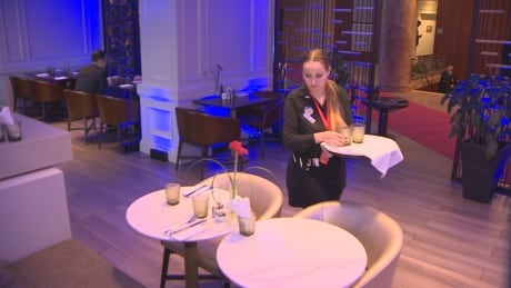Kateryna Tsurkan, 26, a Ukrainian refugee from Odesa, prepares at table at the Halifax Westin Hotel, where top diplomats, soldiers and security officials met over the weekend to discuss the fate of her country. Kateryna Tsurkan