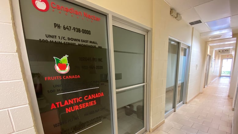 A sign on a glass door in a narrow corridor holds the names Canadian Nectar Products, Fruits Canada and Atlantic Canada Nurseries.