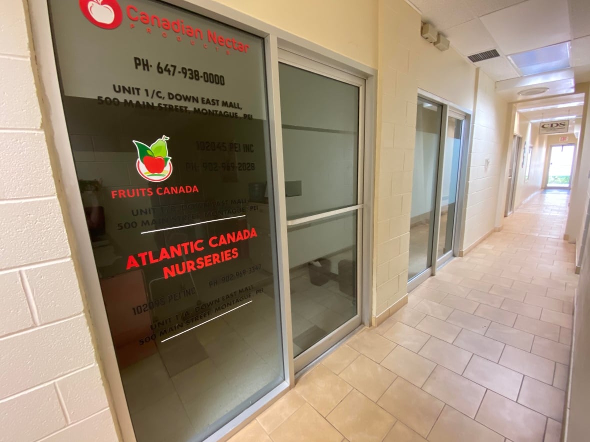 A sign on a glass door in a narrow corridor holds the names Canadian Nectar Products, Fruits Canada and Atlantic Canada Nurseries.