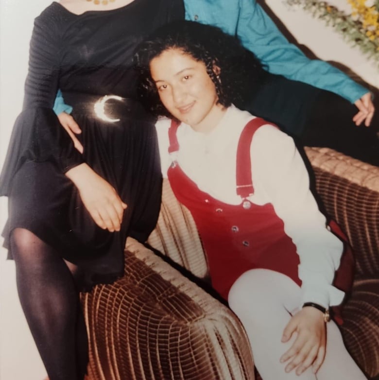 Three girls sitting on a chair with a smile.