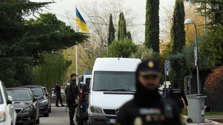 Spanish policemen on Wednesday stand next to an Ukrainian flag while securing the area after a letter bomb was sent to Ukraine's embassy in Madrid. 1245237471