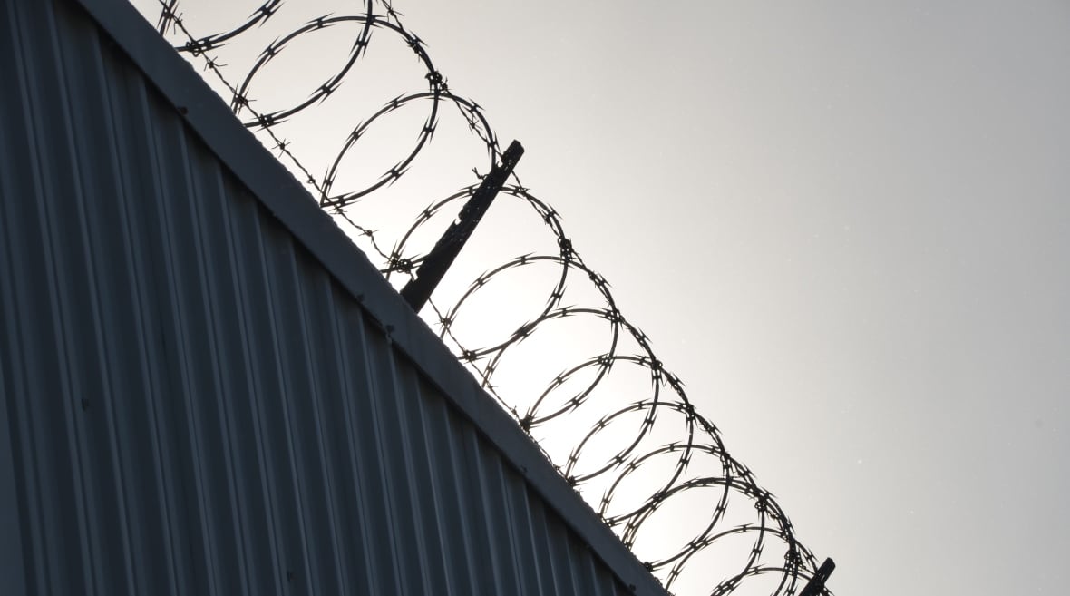 Rings of razor wire line the top of a steel wall at the Sudbury Jail 