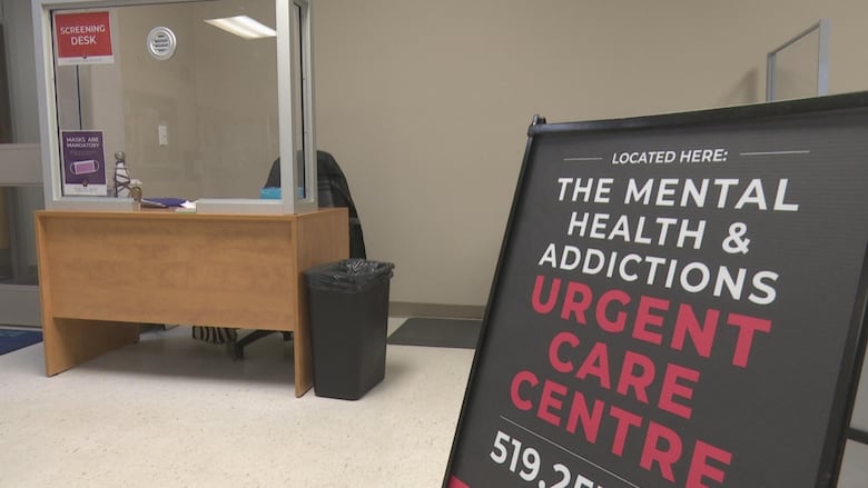 A waiting room with a sign that reads "located here: the mental health & addictions urgent care centre."