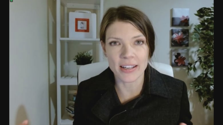 Young brown haired woman looking at camera for zoom interview.