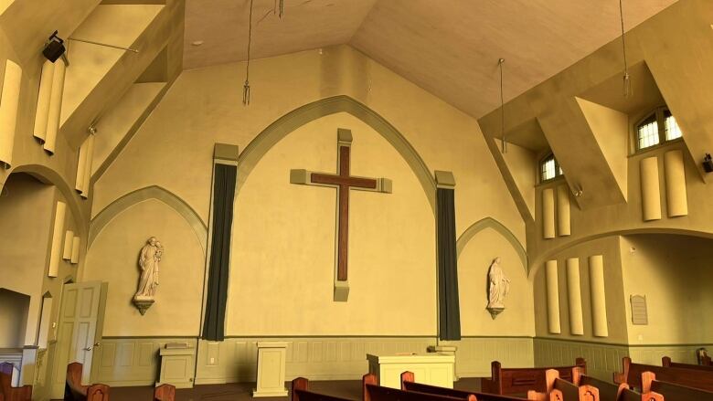 A large wooden cross hangs inside the former church. 