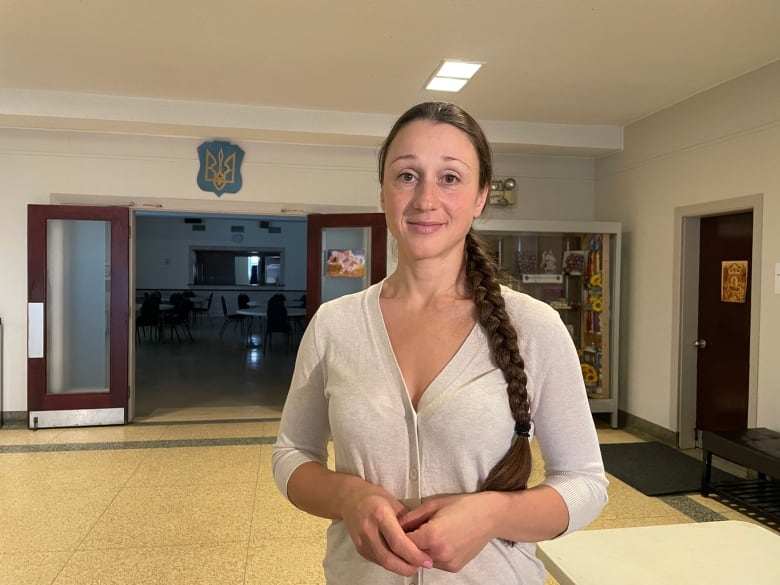 Femme dans une longue tresse à moitié souriante à la caméra