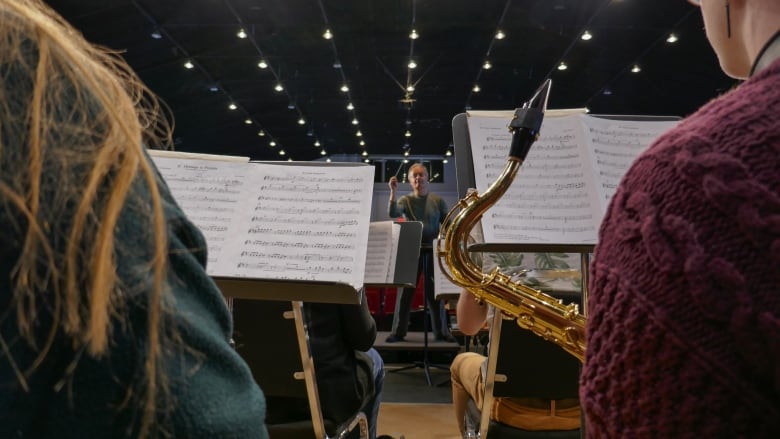 Members of the wind symphony sit tightly together as the conductor is about to begin.