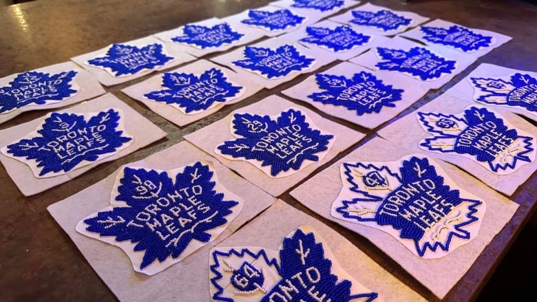 Indigenous-style beaded medallions featuring the logo of the Toronto Maple Leafs hockey club.