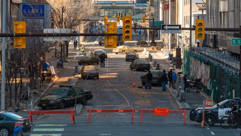 Un plateau de tournage est représenté au centre-ville de Calgary avec des routes fermées et des voitures abandonnées.