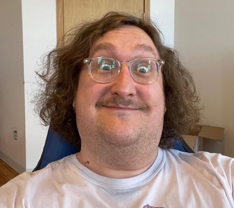 A selfie of a bespectacled man with chin-length chair making a goofy face. 