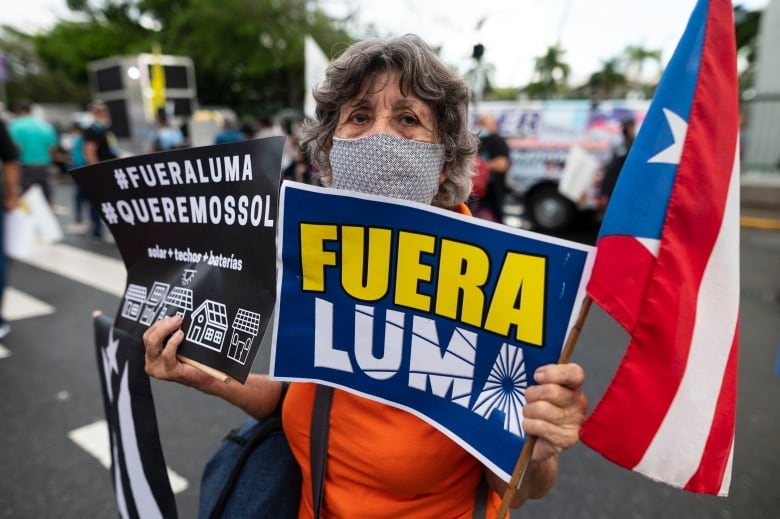 A protester holds a sign saying 'LUMA Out!' during a 2021 march in San Juan, Puerto Rico.