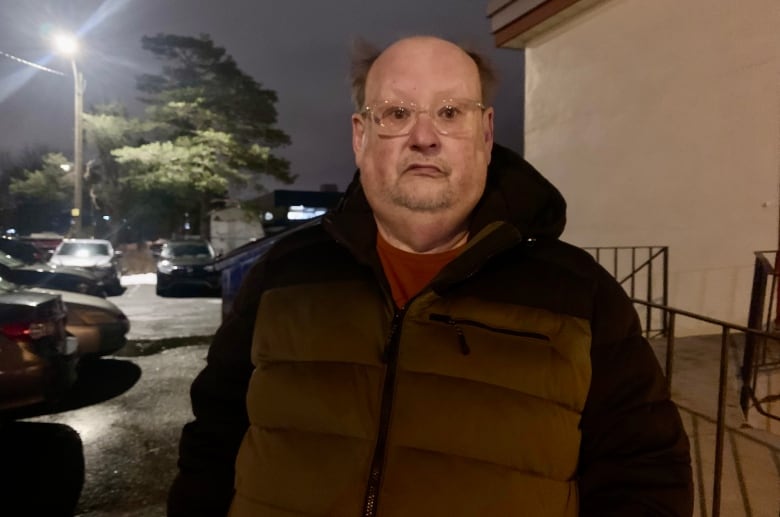 A man wearing a winter coat looks into the camera.