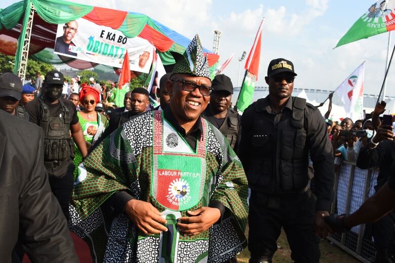 A man in a native head dress is shown at a campaign events.