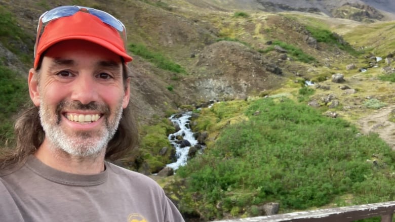 A man smiles during a walk outside.