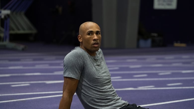 An athlete sits on the ground to rest during a training session.