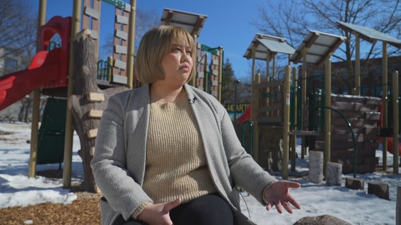 Photo of Jess Tomas sitting in a playground