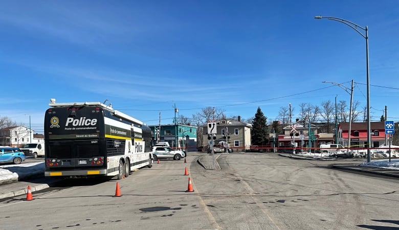 Cones surround a police bus to delineate a command post. 