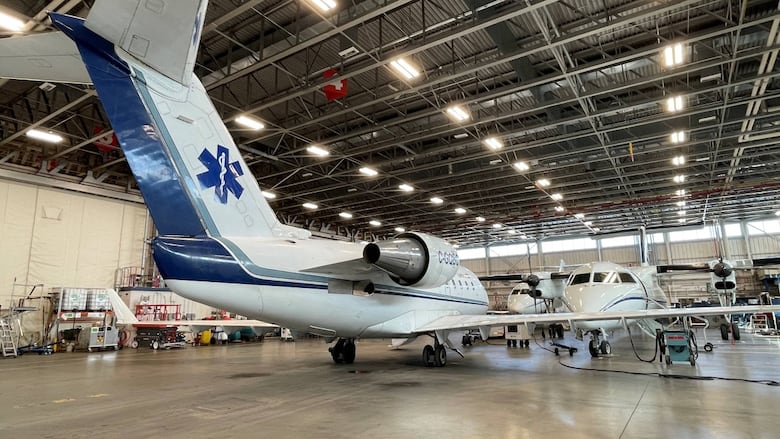 A white and blue ambulance plane