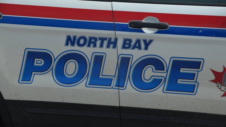 The side of a North Bay Police car painted red, white and blue 